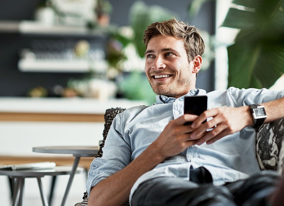 Professional man relaxing at home holding smartphone