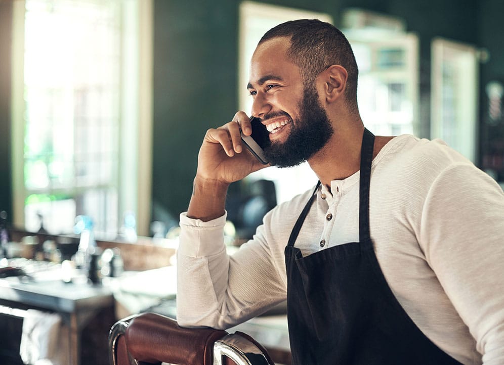 Man talking with customer on phone at small business salon